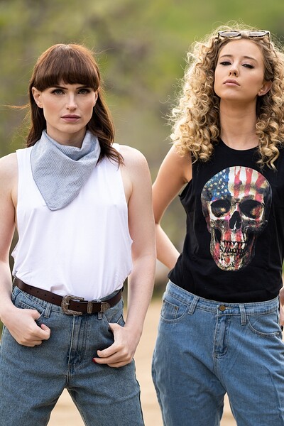 Natalie Mars and Haley Reed intimately slide their hands into each other's back pockets, exchanging flirty looks.