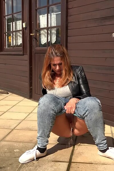 A gorgeous girl in denims pisses outdoors.
