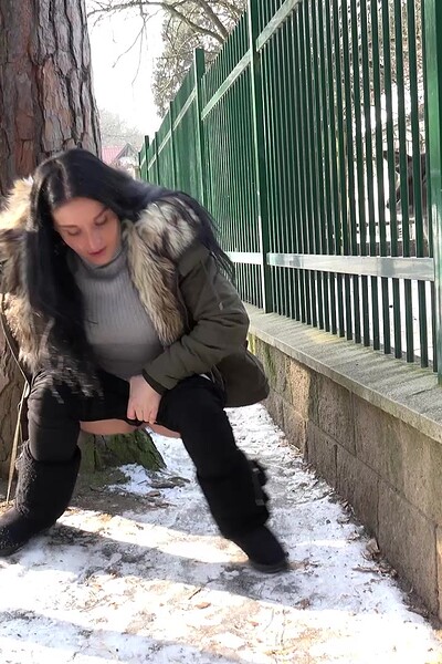 A dark-haired babe squats and sprays a steaming hot stream of piss onto the snow, relieved to empty her bladder.