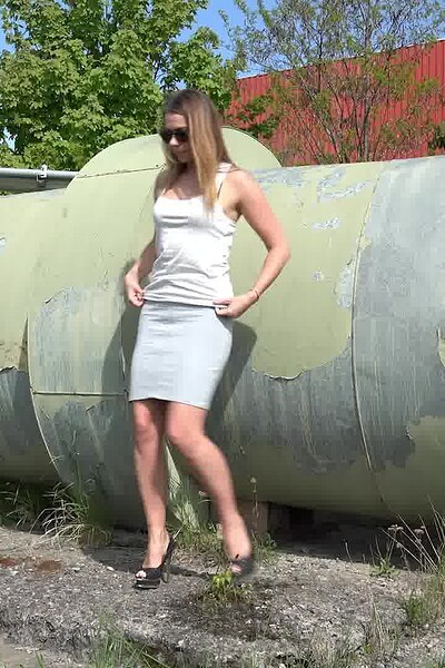 A gorgeous blonde in a tight pencil skirt stands at a pipe and releases a long, desperate stream of her golden piss onto the floor.
