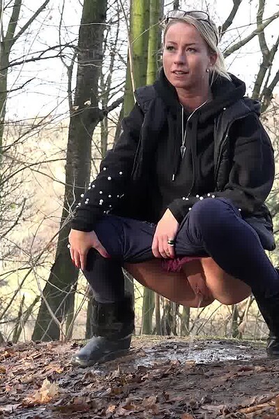 Licky Lex confidently squats on a public path, spraying her juices while smiling at the camera.