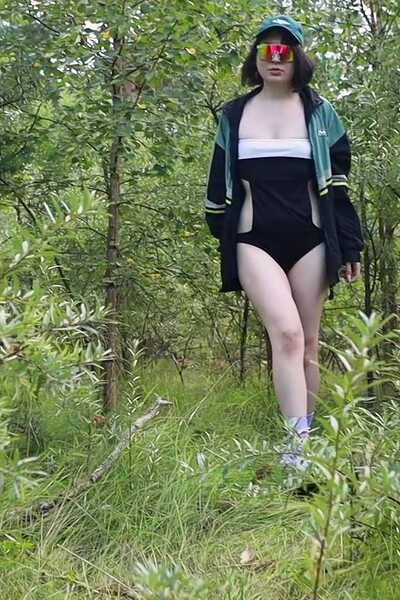 A dark-haired babe pulls down her panties, fingers her pussy, and pisses a messy stream onto the grass.
