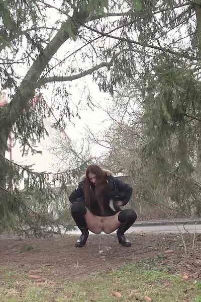 A desperate brunette squats to piss in public, lifting her minidress as cars pass, her face showing pure relief.